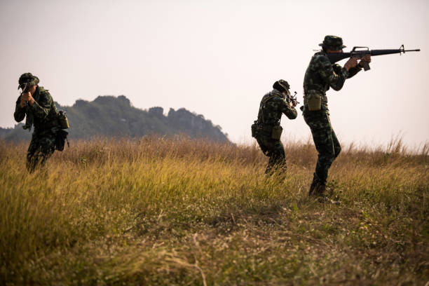 istock Squad of soldiers patrolling across the deep forest area. 1055394332