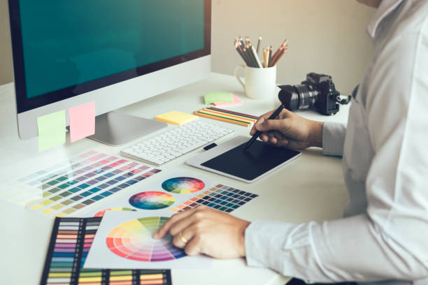 młody projektant siedzi w biurze firmy i pracuje nad cyfrowym tabletem graficznym. - photogenic zdjęcia i obrazy z banku zdjęć