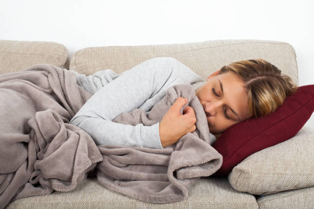 istock Sick woman lying on the couch 1055398384