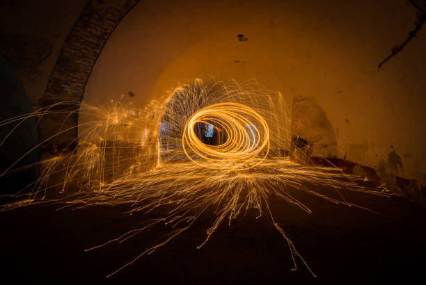 istock Painting with light - fire spinning in closed space 1055401012