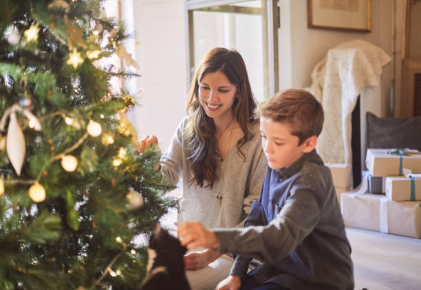 istock Celebrating Christmas, mother and son decorating a tree. 1055405996