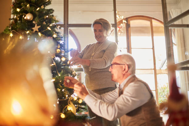 istock Senior couple decorating the christmas tree at home. 1055406814