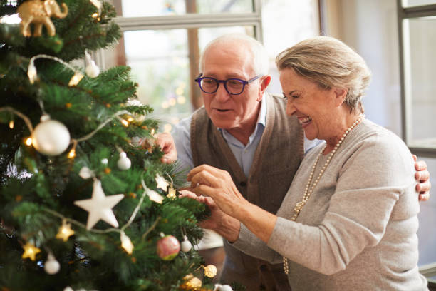 istock Senior couple decorating the christmas tree at home. 1055406842