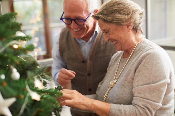 istock Senior couple decorating the christmas tree at home. 1055406874