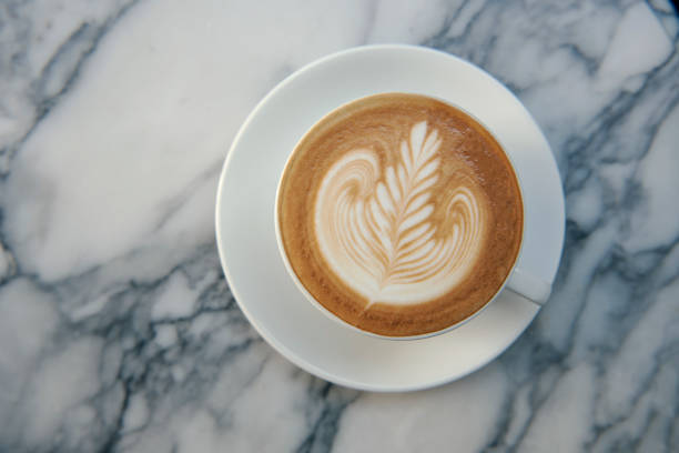 istock latte or Cappuccino with frothy foam, coffee cup top view on table in cafe. 1055408132