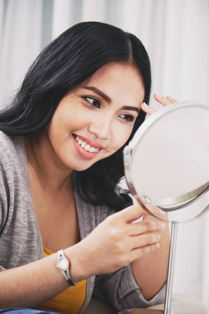 istock Filipino lady smiling and adjusting makeup 1055412352
