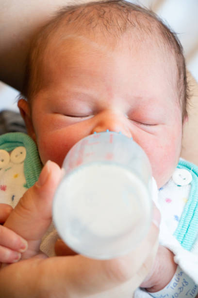 istock Mother feeds newborn with baby bottle 1055412564