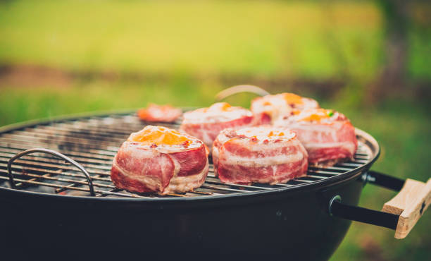istock Making home made Beer Can Bacon Burgers on barbecue grill. 1055416262