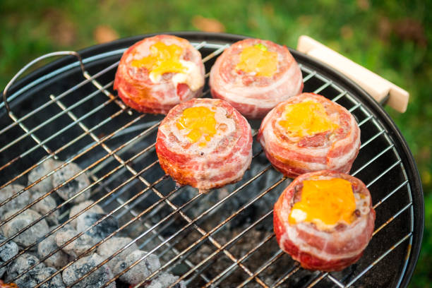 istock Making home made Beer Can Bacon Burgers on barbecue grill. 1055416430