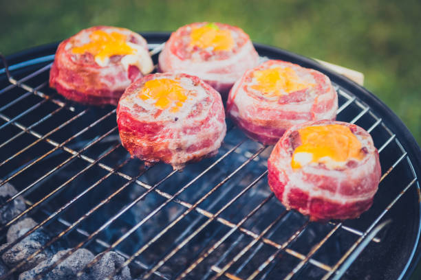 istock Making home made Beer Can Bacon Burgers on barbecue grill. 1055416458