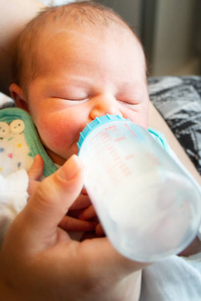 istock Mother feeds newborn with baby bottle 1055417790