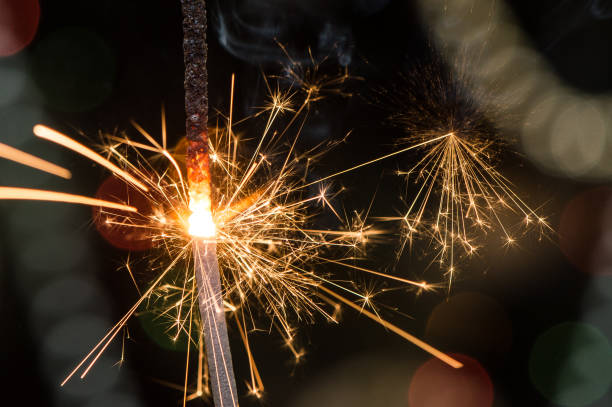 istock Burning sparkler with sparks bursting in air. 1055419942