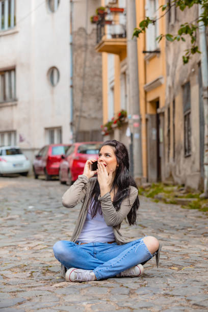 istock Cute young woman using cellphone in urban surroundings. 1055422880
