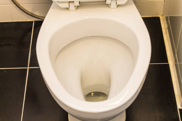 istock White toilet Black tile floor, orange light 1055425448
