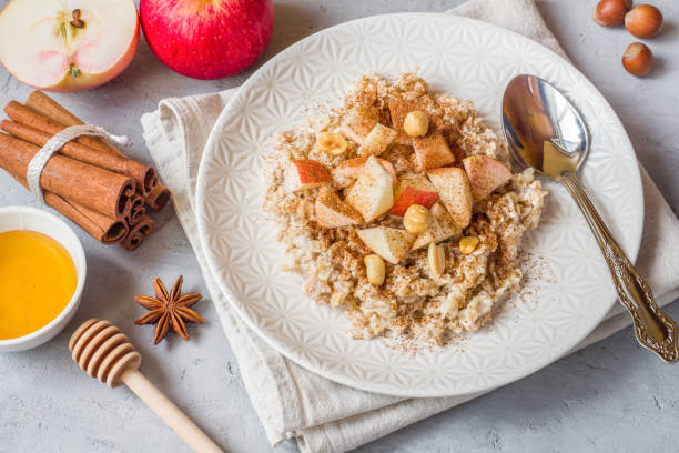 istock Oatmeal with fresh apples, nuts and cinnamon for Breakfast on the table, close-up, horizontal 1055427274