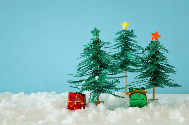 istock Image of paper christmas trees over white snow. 1055429920