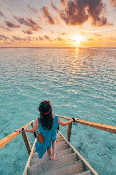 junge frau jagt die sonne auf den malediven - beach tourist resort one person one woman only stock-fotos und bilder