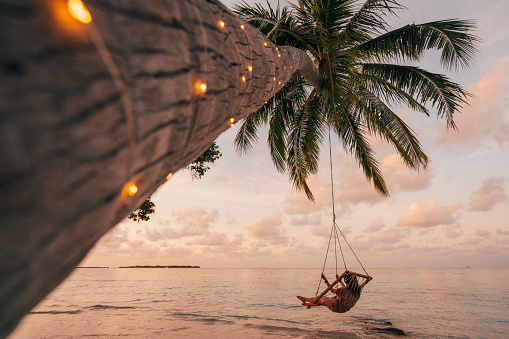 Adulto joven relajante en un columpio en un paraíso tropical photo