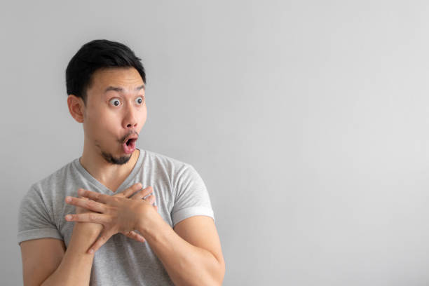 Wow and shocked face of man point to present an empty space of content. Wow and shocked face of Asian man point to present an empty space of content. Advertising model concept. funny shock stock pictures, royalty-free photos & images