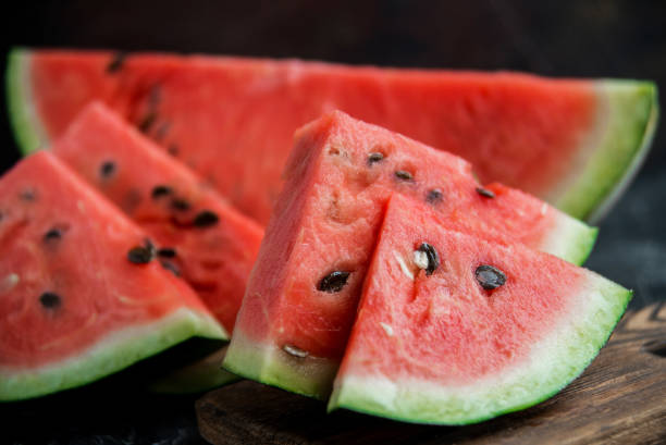 istock Slices of fresh ripe watermelon on a dark background. 1055432352