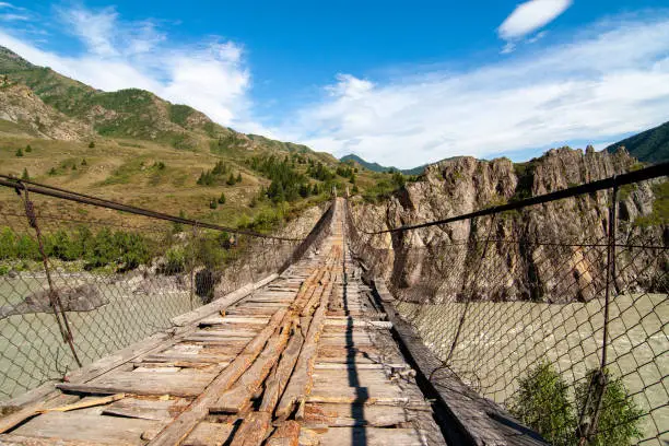 The hanging wooden bridge over the mountain river Katun, Altai