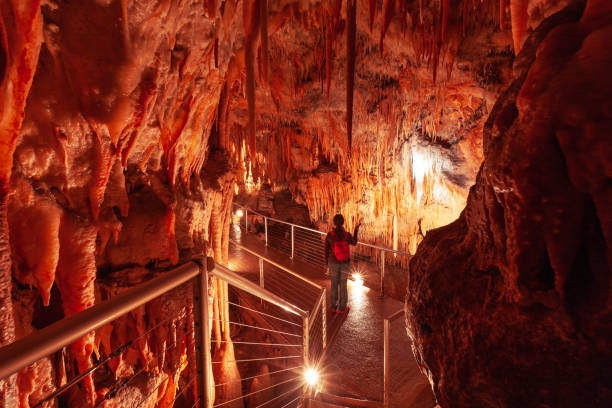 istock Tourist pointing a flashlight at stalactites in limestone cave in Australia 1055436192