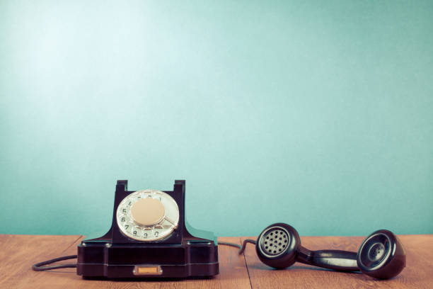 istock Retro rotary telephone on table in front mint green background. Old instagram style filtered photo 1055438090