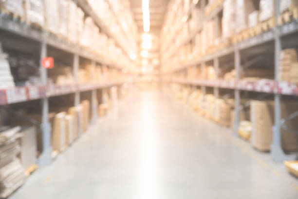 istock Blurred boxes on rows of shelves in warm light warehouse background. 1055439862