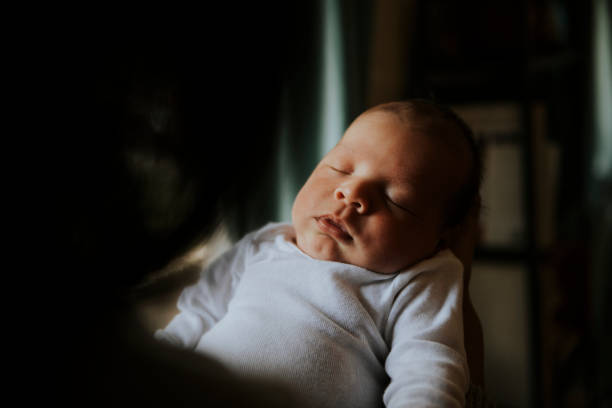 istock Mother holding her baby indoors 1055440688