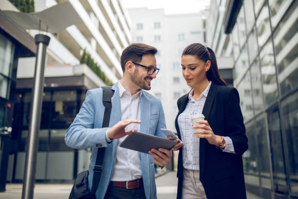 istock Business team discussing business project using tablet computer outdoors 1055440762