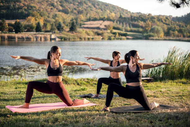istock Women doing yoga on the lake 1055442572