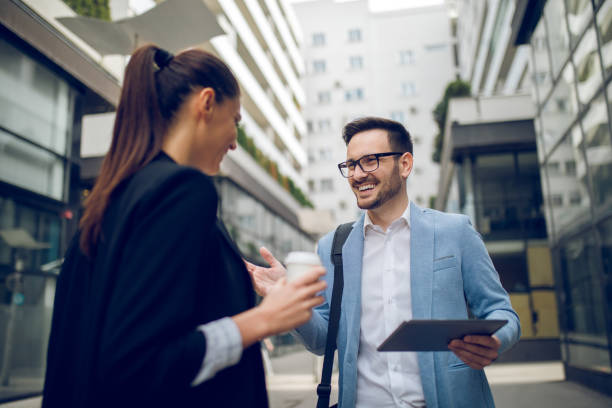 istock Business team discussing business project using tablet computer outdoors 1055442838