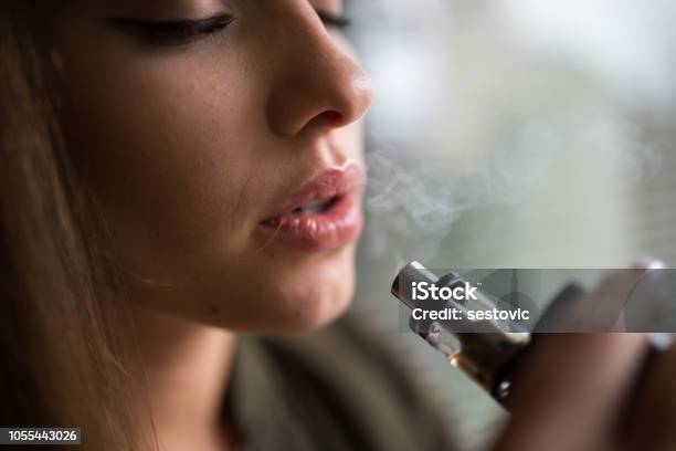 Donna Che Fuma Una Sigaretta Elettronica - Fotografie stock e altre immagini di Sigaretta elettronica - Sigaretta elettronica, Fumare, Industria elettronica