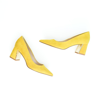 Women fashion background with yellow shoes on white. Flat lay, top view.