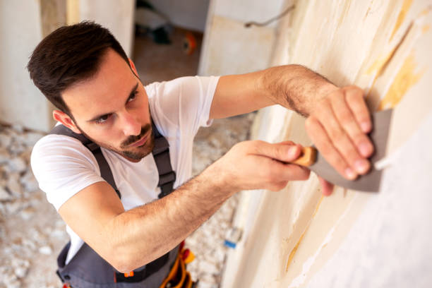 istock Removing of old wallpaper from the wall 1055443184