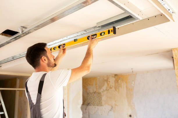 istock House renovation worker checking the alignment of a ceiling 1055446126