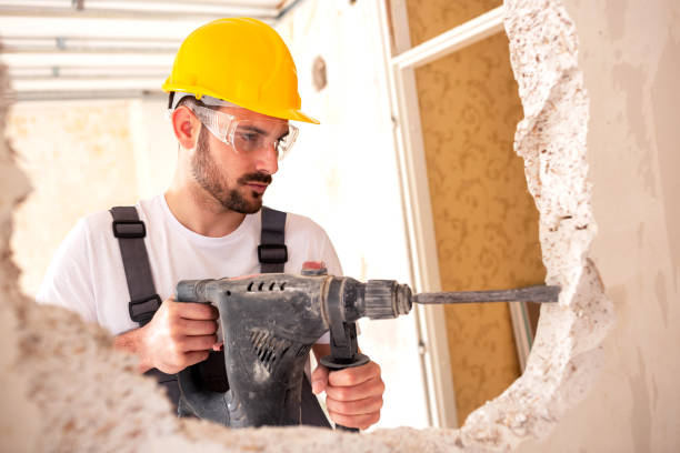 Electrician working with masonry tools Electrician working with masonry tools wearing protective and safety gear helmet hardhat protective glove safety stock pictures, royalty-free photos & images