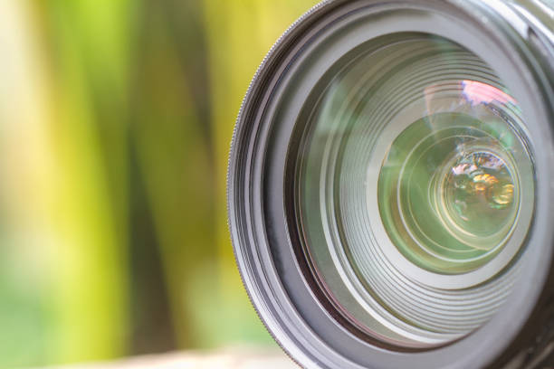 istock Camera lens with lense reflections modern ultra zoom photo camera front view,black DSLR camera,blurred background 1055448926