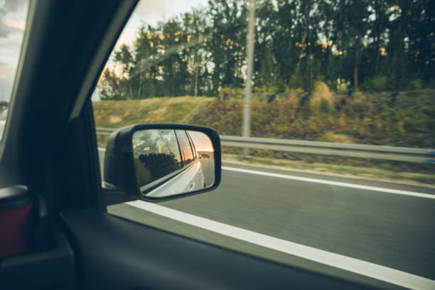 istock car on highway. sunset in car mirror reflection 1055449868