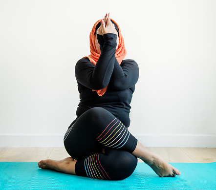 Mujer islámica haciendo yoga en la sala de photo