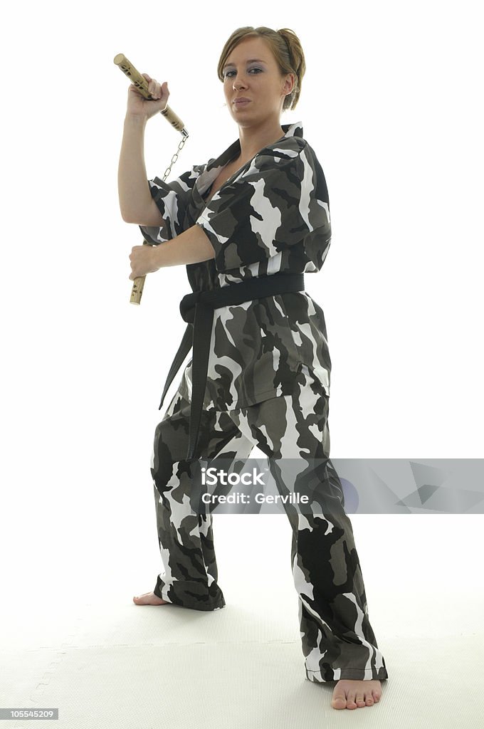 Camo chucks Martial artist with nunchakus. Adult Stock Photo