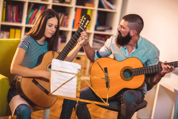 istock Guitar teacher teaching the girl at home. 1055457536