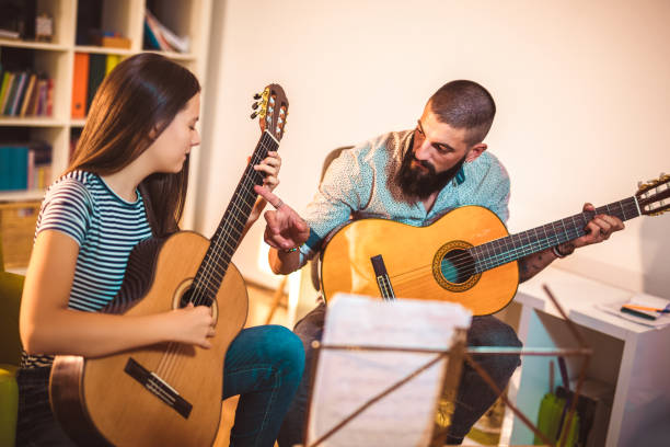 istock Guitar teacher teaching the girl at home. 1055460576