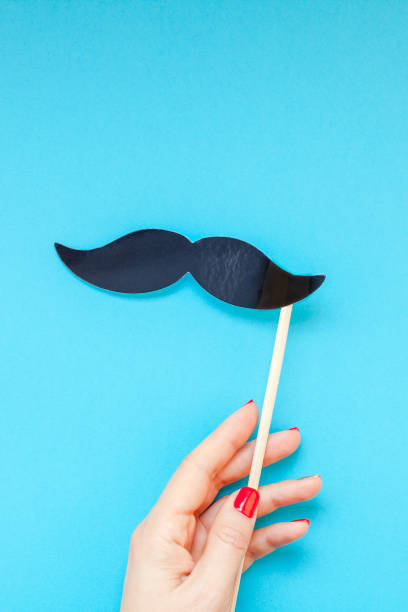 Paper moustaches for men fathers dad concept Creative flatlay top view retro black paper photo booth props moustaches woman hands turquoise background copy space. Men health awareness month fathers day masculinity concept blog social media women movember mustache facial hair stock pictures, royalty-free photos & images