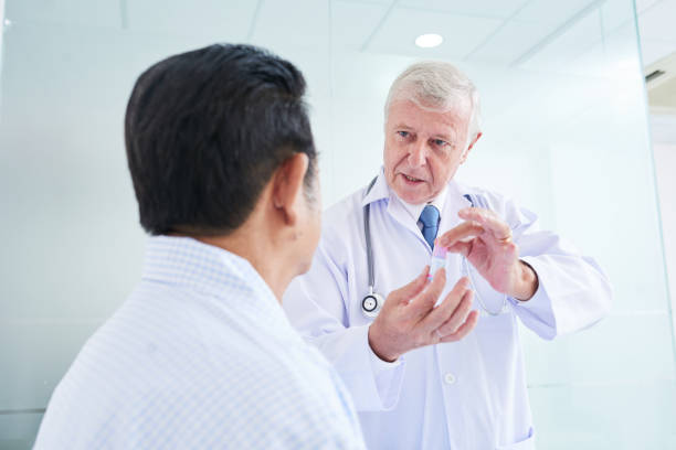 istock Elderly doctor demonstrating cure to patient 1055465550