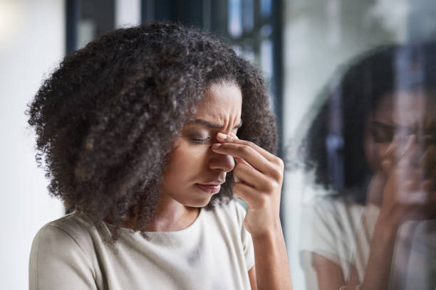 This headache is getting in the way of her work Cropped shot of an attractive young businesswoman suffering with a headache while standing in her office managing stress stock pictures, royalty-free photos & images