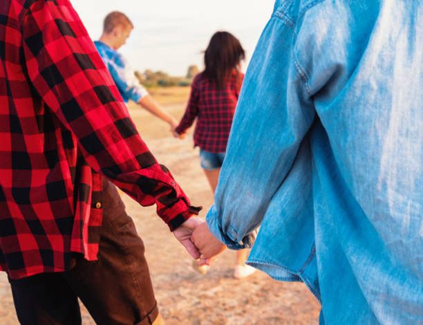 istock friends on beach together walking during sunset 1055467422