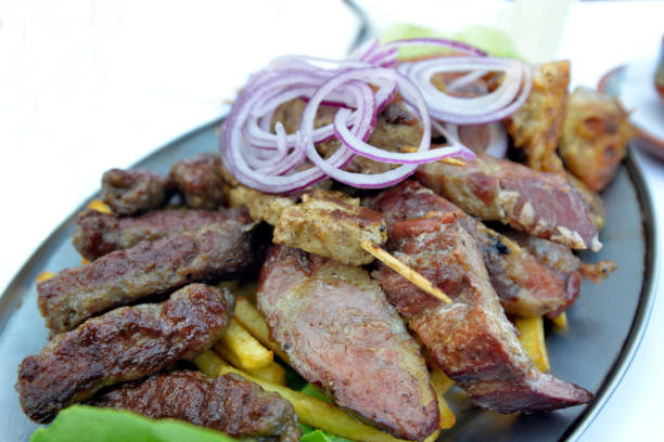 Various grilled meat on a metal plate on the table in the restaurant