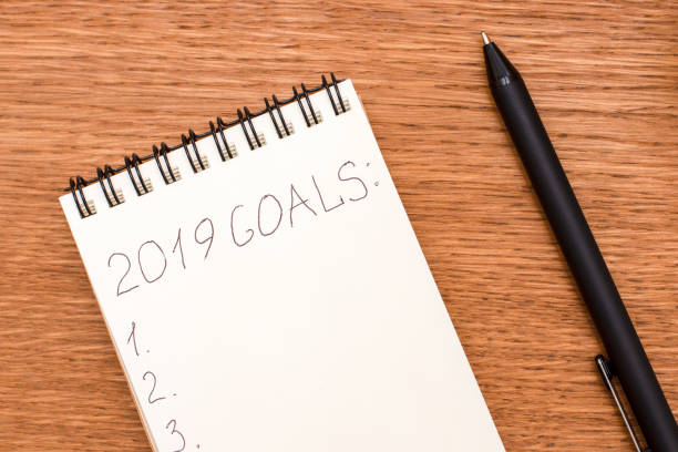 istock Notebook with goals for 2019 on a wooden surface 1055470826