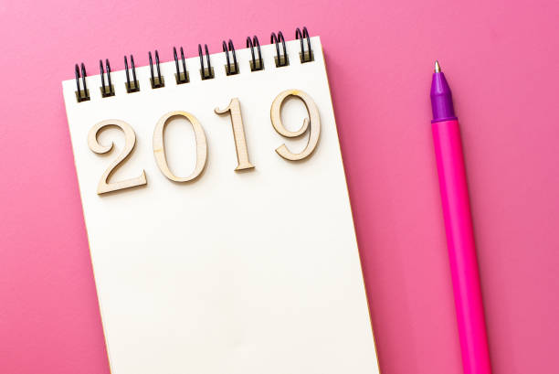 istock Notebook with the inscription 2019, pen purple table 1055473306